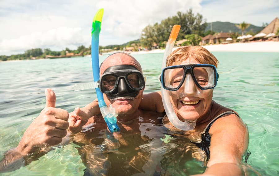 Senior couple smiling while snorkeling in a tropical sea