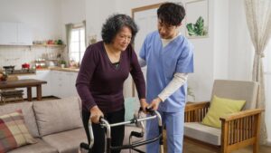 Physical therapist assists client standing and learning to use walker at home